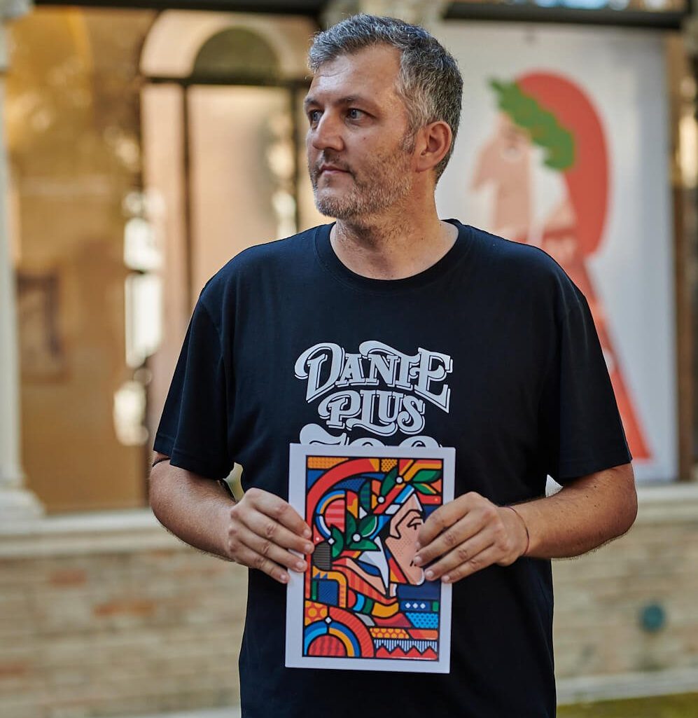 Marco Miccoli tiene in mano un'illustrazione del volto di Dante